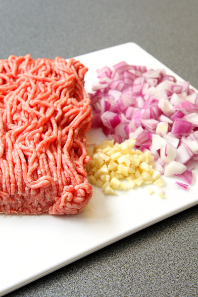 碎肉，洋葱和大蒜放在白板上
