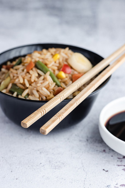蔬菜炒饭和鸡蛋，用筷子和酱油盛在碗里。中国菜