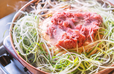 牛肉烧烤韩式烤肉在首尔的韩国餐厅，生活方式新鲜的韩国菜烹饪铜锅与切片烧烤，近距离，拷贝空间