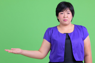 年轻美丽的超重亚洲女人显示一些东西