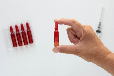 Top view of woman hand holding ampoule with vitami
