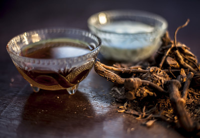生的阿育吠陀药草chitrak/Plumbago zeylanica的根放在棕色光亮的表面，与一些脱