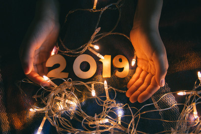 新年前夕，孩子们的手放在毯子上，上面有闪亮的花环和数字2019