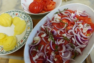 Provençal蔬菜田在烤盘准备西红柿土豆煮在水洋葱橄榄油和普罗旺斯香草