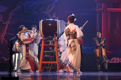 日本传统的性能。一群女演员穿着传统的红白和服和狐狸面具在舞台上跳舞和击鼓。