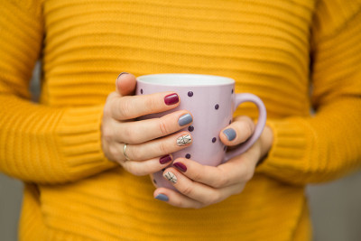 女性双手捧着一杯茶。