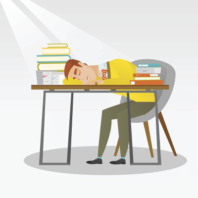 学生拿着书在书桌前睡觉