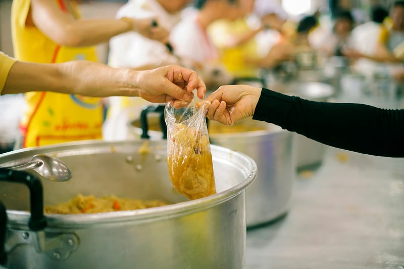 志愿者为乞丐提供食物:概念喂养和帮助