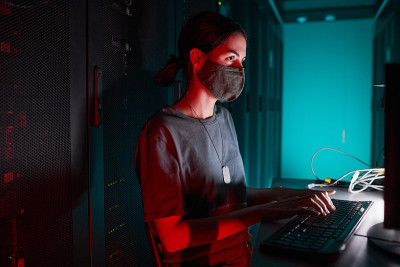 在数据中心戴口罩的女性网络工程师