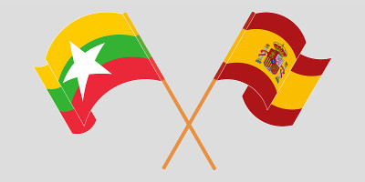 Crossed and waving flags of Myanmar and Spain