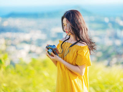 一个年轻的女旅行者看着照相机