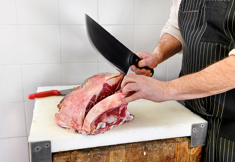 屠夫用切肉刀切肋眼牛排