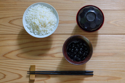 在煮过的黑大豆餐具孤立在木桌上。