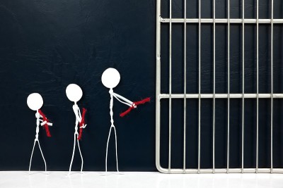 年轻的棍棒人图形手铐与红绳去监狱监狱在黑暗的背景。降低未成年人刑事责任、未成年人监禁、未成年人犯罪、