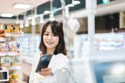 一名年轻女子在超市用智能手机支付