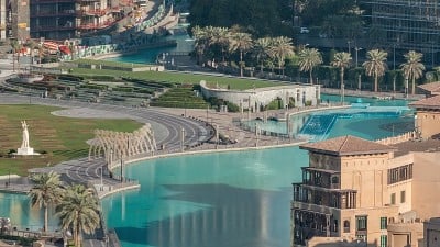 人工湖上的桥和一些人在公园里散步的顶部近景