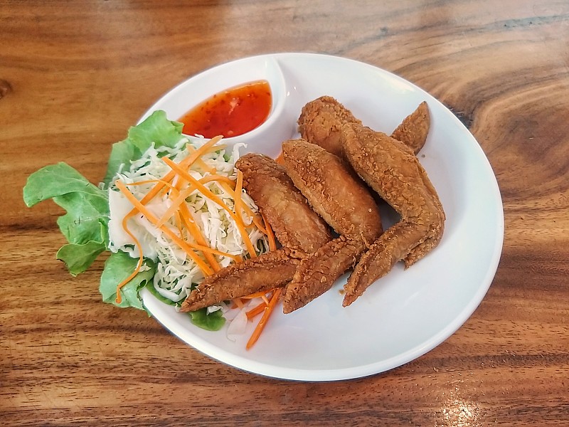 关闭炸鸡翅与蔬菜和蘸酱。