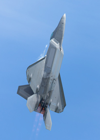 F-22猛禽在美丽的光线下高G爬升，在机翼和加力燃烧室周围形成凝结痕迹