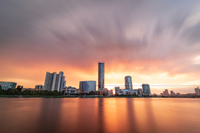美丽的多云日落在城市池塘。长时间曝光的叶卡捷琳堡城市景观，俄罗斯与摩天大楼反映在水中