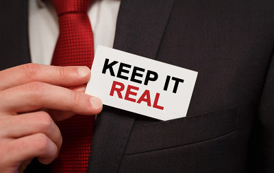 商人把写着“Keep It Real”的卡片放在口袋里