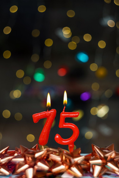 第75张生日或周年纪念的快乐贺卡。这张图片是一系列不同数字燃烧蜡烛的照片的一部分，从1到100