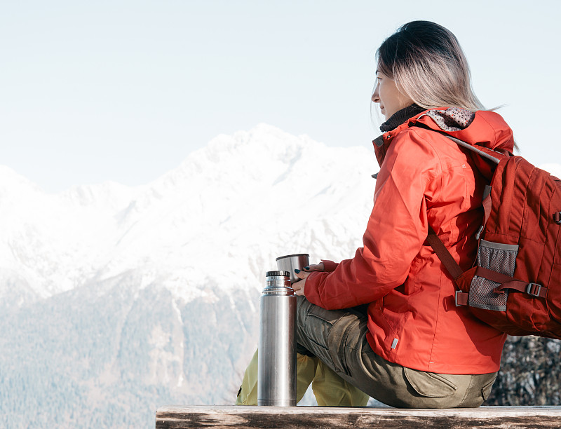 旅人女人在冬天的山上休息。