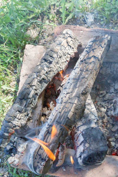 在烤架上把木头烧成炭来煮肉