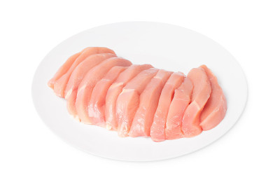 生鸡肉。生鸡块放在白色盘子上，背景与迷迭香树叶隔离。生鸡肉牛排。