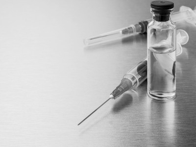 在抛光的金属背景上放置注射器和安瓿。
