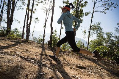 健身女子越野跑在日出热带森林山顶