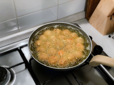 用滚烫的油在平底锅里煎丸子。