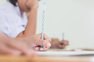 学生在高中、亚洲考场、测试或考试中使用钢笔在白纸上写信息是评估的目的是衡量知识、技能、能力倾向、教育