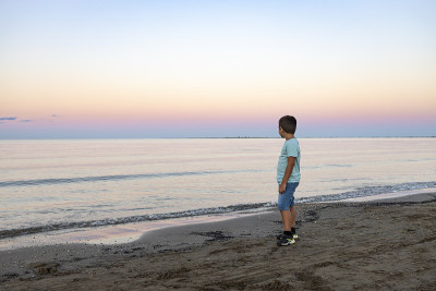 孤独的孩子看着夕阳下的大海