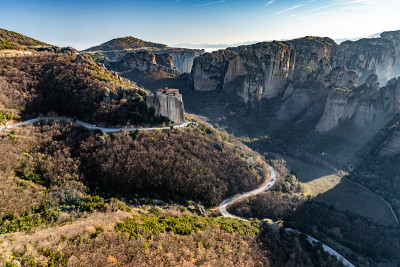 鲁萨努修道院的鸟瞰图和令人惊叹的风景如画的山谷和地标峡谷的迈泰奥拉日落，卡拉巴卡，希腊，影子，扭曲的