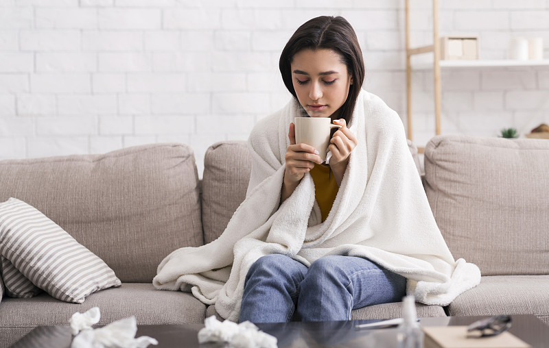 传染性疾病的流行。年轻女孩在家喝药茶治疗病毒