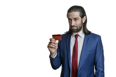 手里拿着信用卡的人孤立在白色背景上。