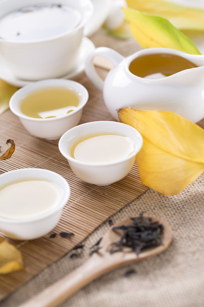 桌上放着白茶杯和秋叶。秋茶。