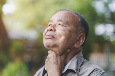 一位老人因为流感或COVID-19而喉咙痛。老年人的疾病概念。