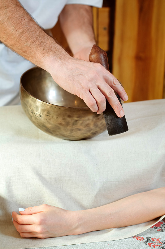 Man hands playing a singing bowls like Tibetan Sin