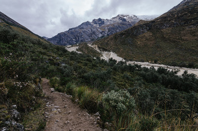 在秘鲁的圣克鲁斯峡谷之间的山脉徒步旅行中，山谷中有雪崩留下的痕迹和植被