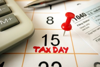显示日期为2020年7月15日的月历，以1040表格计算器和笔标记为纳税日