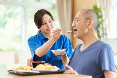 帮助老人吃饭的看护者