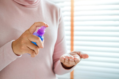 女性手喷酒精消毒液消毒皮肤，预防病毒和疾病