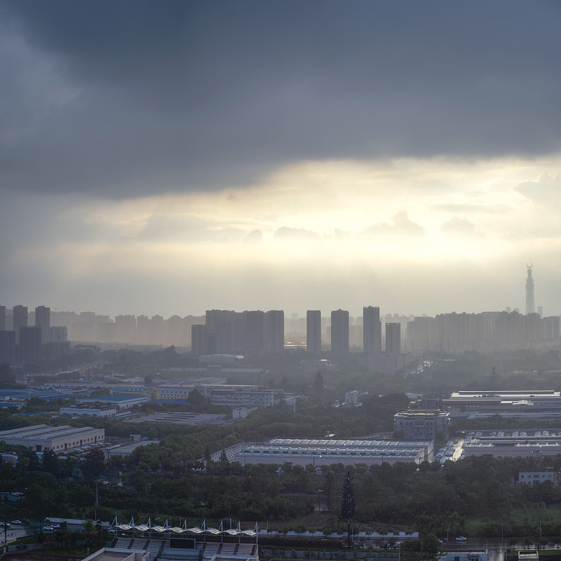 太阳在雨中穿过云层形成潮汐效应的城市