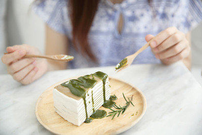 年轻的亚洲女子吃绿茶饼甜的食物