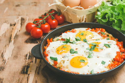 煎锅里美味健康的Shakshuka。西红柿、甜椒、蔬菜和香草煎蛋。中东传统菜肴。