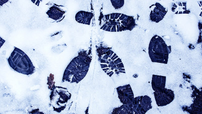 冬天雪地里肮脏的脚印。靴子在路上的踪迹