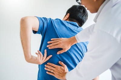 理疗医生向患者咨询背部问题理疗概念