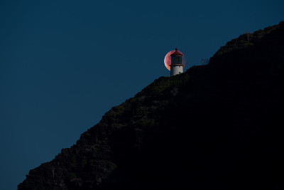 夏威夷檀香山，超级血狼月亮在马卡普灯塔后面黯然无光