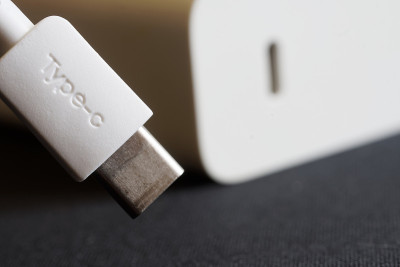 一个白色usb type-c连接器在一个白色电源和快速充电器旁边的黑色背景。快速数据传输的概念和现代